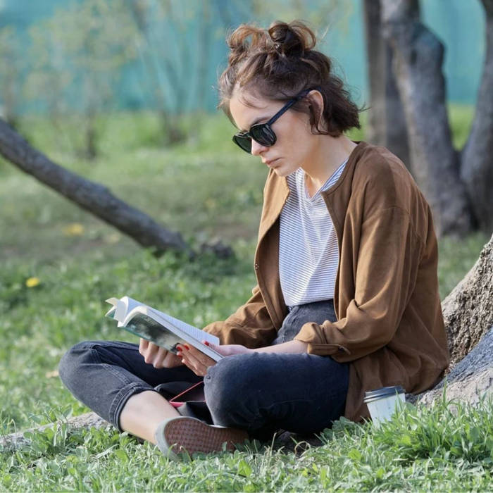 Mujer leyendo al aire libre, Cómo crear hábitos saludables que perduren en el tiempo