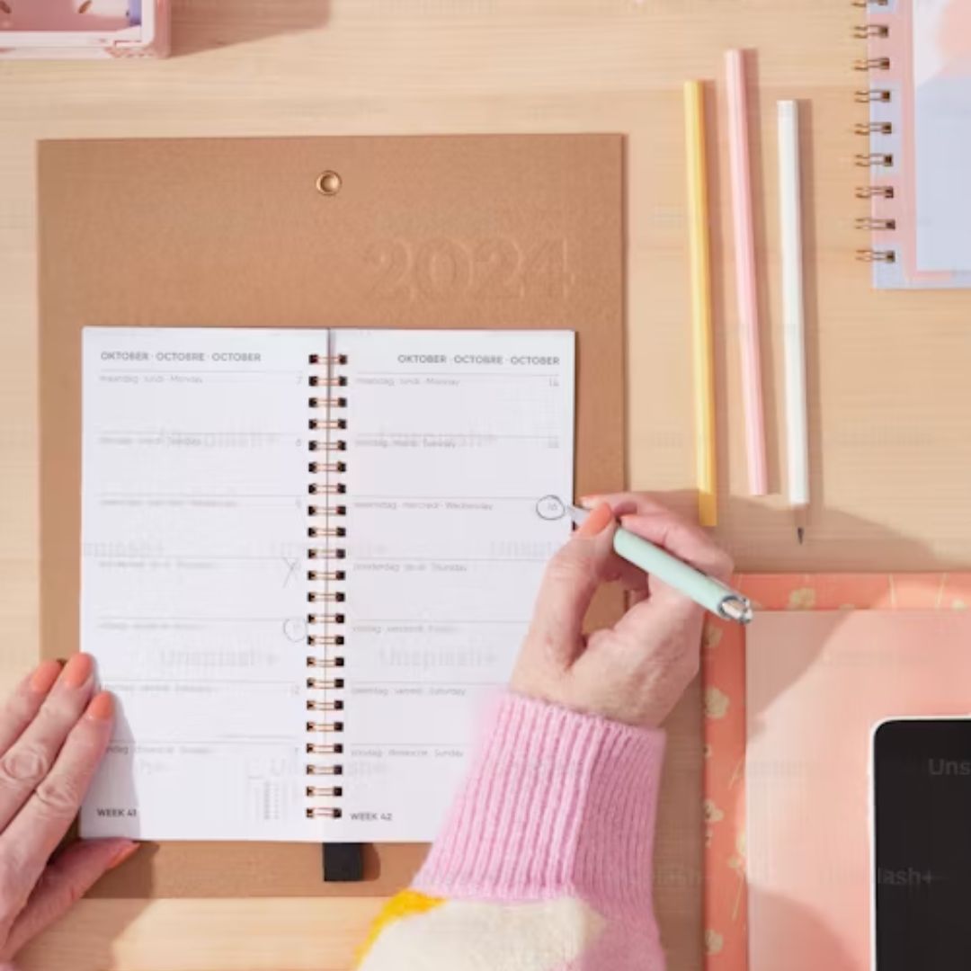 Mujer escribiendo en una agenda, Reajusta y Alcanza tus Metas Antes de Diciembre