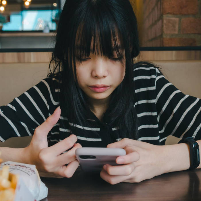 ¿Qué es la dopamina y por qué las redes sociales la disparan? Adolescente usando el móvil con redes sociales